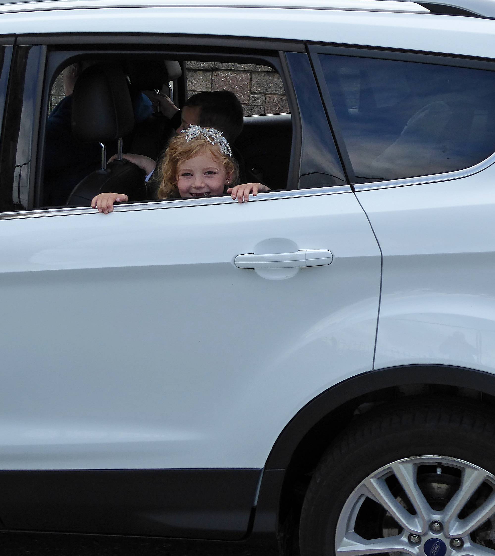 One of the princesses peering out of the car