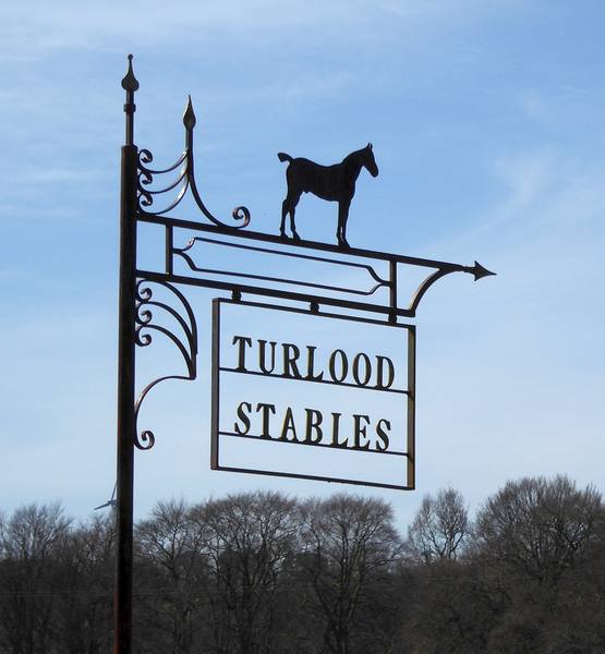 Sign for Turlood Stables at junction