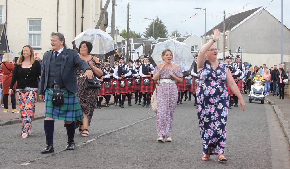 Procession in  Coalburn Road. Umbrellas up because of light rain