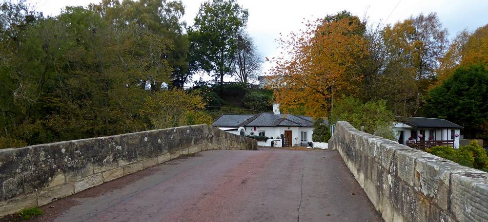 View over Douglasmouth Bridge to white cottage.